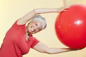 Senior woman practicing with gymnastic ball